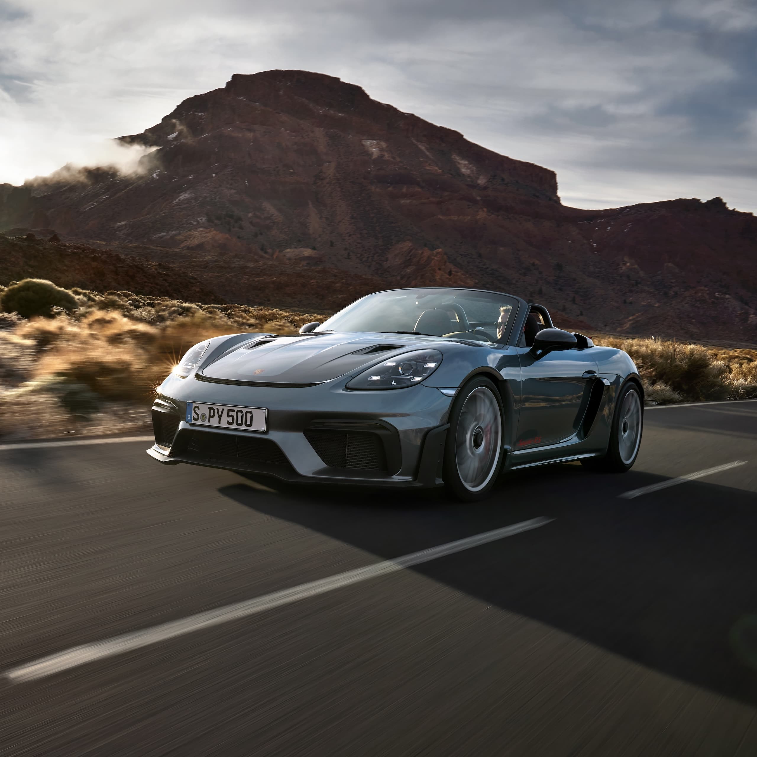 Porsche 718 Spyder RS fährt auf der Strasse zwischen Felsformationen.