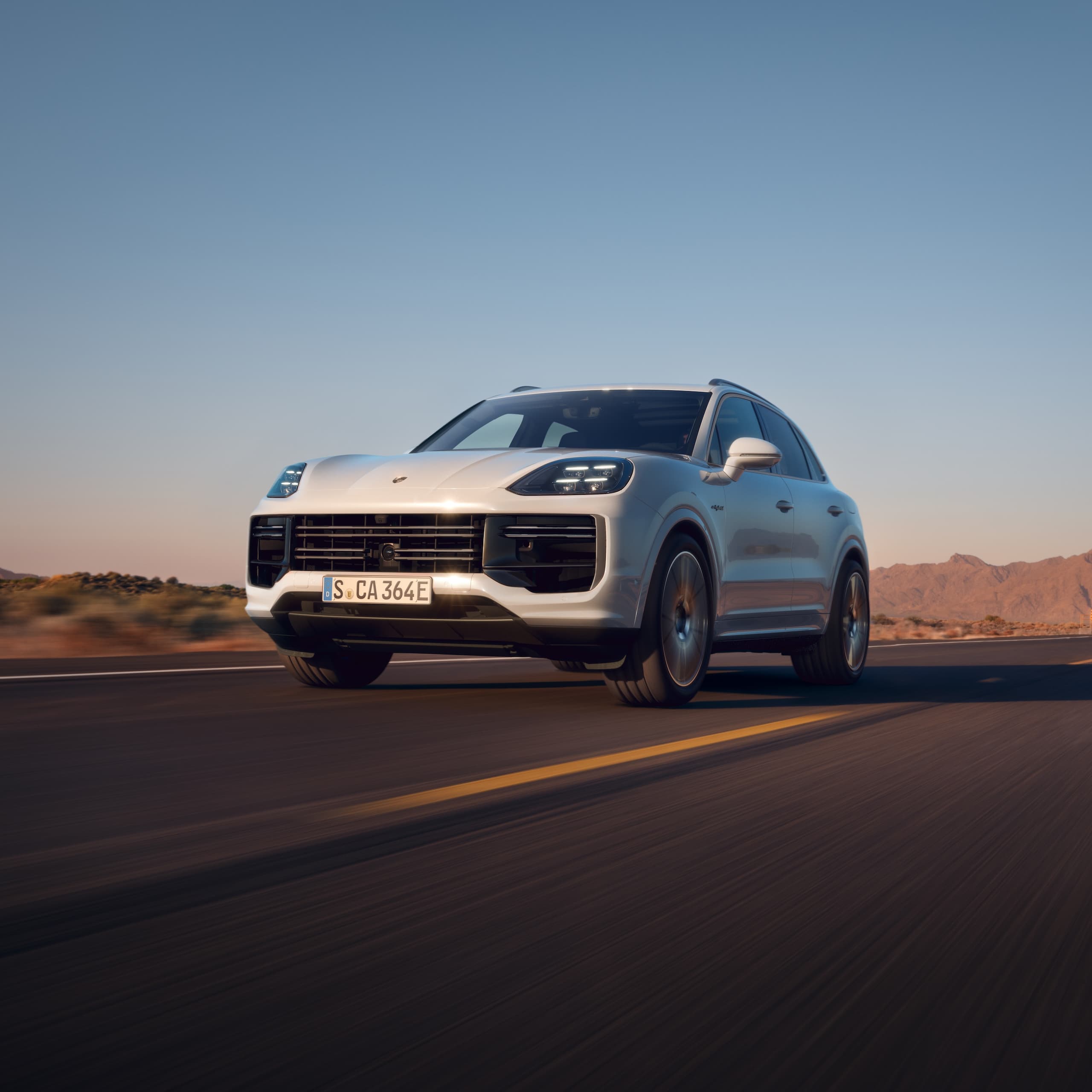 Ein Porsche Cayenne fährt auf offener Strasse.